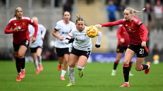 Millie Turner of Manchester United battles for possession with Cornelia Kapocs of Liverpool