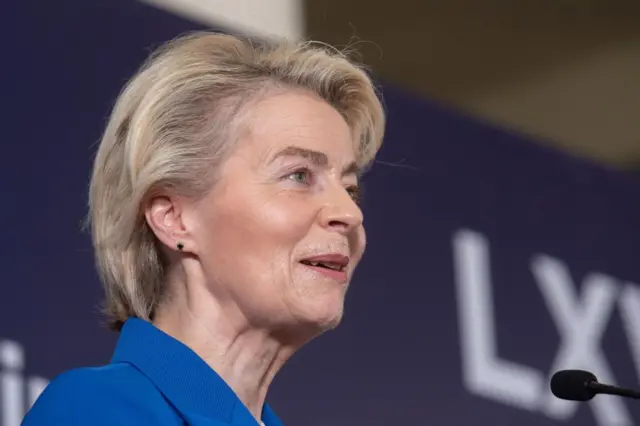 European Commission president Ursula von der Leyen, side profile looking to the right of the image, from the neck up and part of right shoulder, wearing blue jacket, partial microphone on right side. Blurred letters LX in background