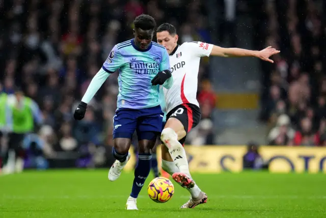 Arsenal's Bukayo Saka (left) and Fulham's Sasa Lukic battle for the ball.