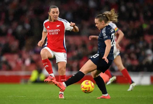 Katie McCabe of Arsenal passes the ball whilst under pressure from Kirsty Hanson of Aston Villa