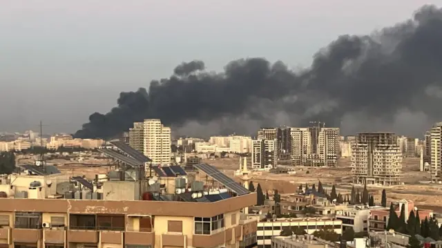 Plume of smoke rising from the city skyline