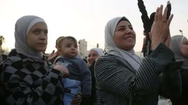 People celebrate the overthrow of Syrian President al-Assad, at the Umayyad Square in Damascus,