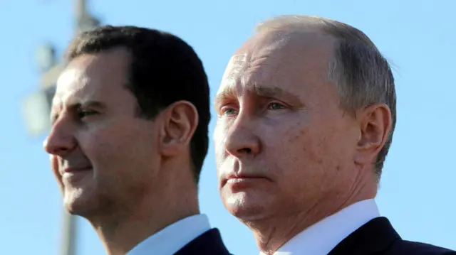 A profile shot of Bashar al-Assad and Vladimir Putin, both in dark blazers and white shirts