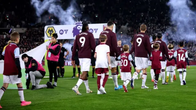 Players of West Ham United enter the pitch wearing shirts in support of their injured teammate, Michail Antonio