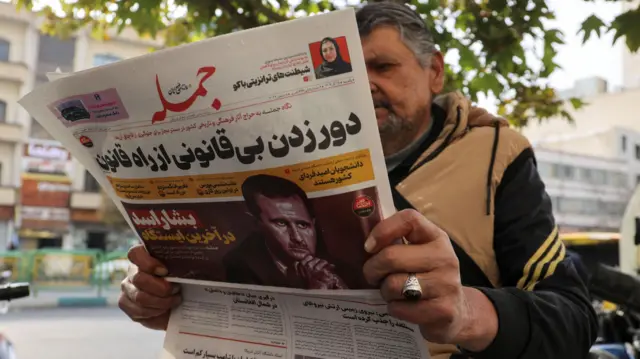 An Iranian man reads a newspaper with a picture of Syrian President Bashar al-Assad in Tehran, Iran December 8, 2024