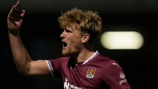 Northampton goalscorer Cameron McGeehan gestures to the crowd in celebration