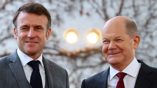 Scholz and Macron in Berlin in November, smiling at the camera, both wearing suits