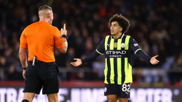 Referee Rob Jones argues with Rico Lewis