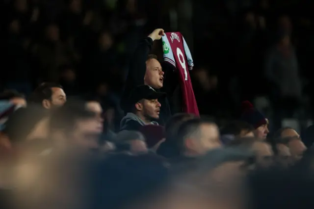 A West Ham United's fan holds up a shirt