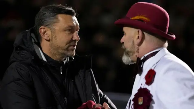 Northampton caretaker manager Ian Sampson shakes hands with the club mascot