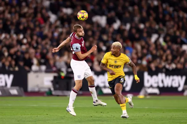 Tomas Soucek of West Ham heads the ball clear as Mario Lemina of Wolverhampton Wanderers challenges