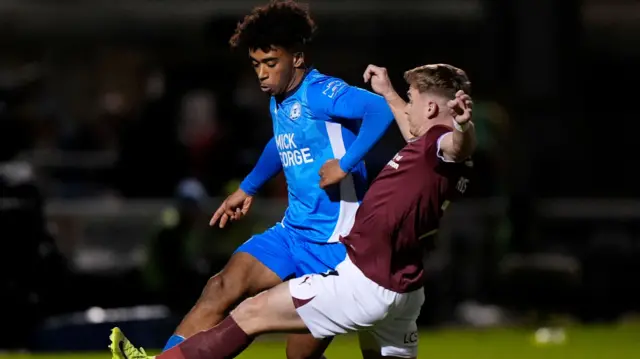 Peterborough United's James Dornelly and Northampton Town's Sam Hoskins battle for the ball