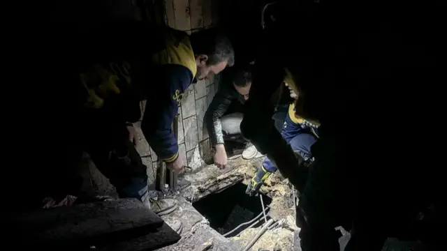 A team in the Sednaya military prison look through a hole in the floor