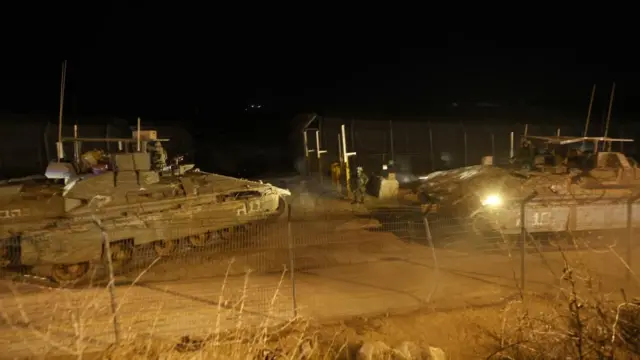 Israeli tanks cross a security fence into the buffer zone with Syria