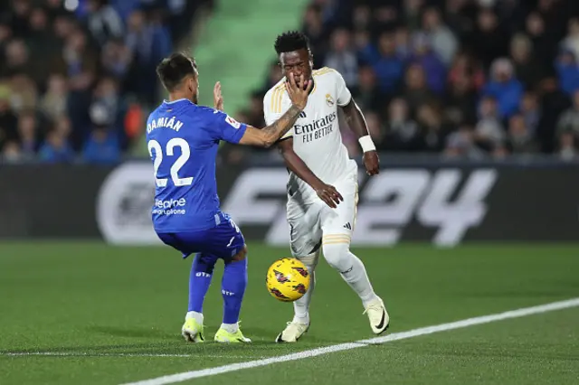 Damian Suarez (L) of Getafe CF grabs the face of Vinicius Junior