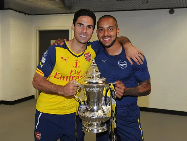 Mikel Arteta and Theo Walcott smile with the FA Cup trophy