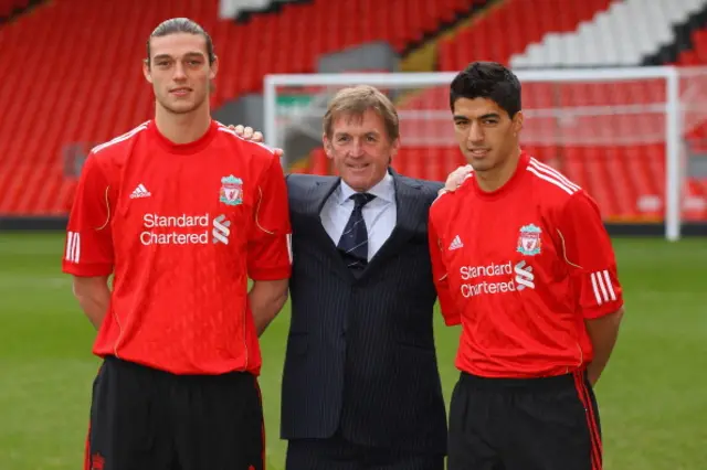 Andy Carroll and Luis Suarez stand beside manager Kenny Dalglish