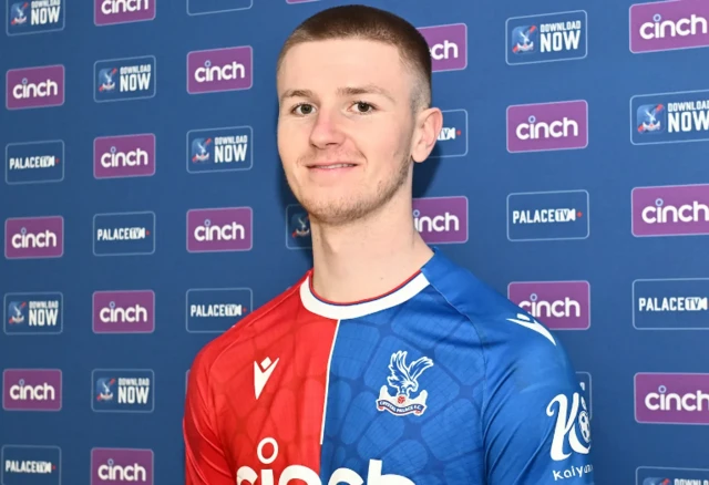 Adam Wharton smiles wearing a Palace shirt