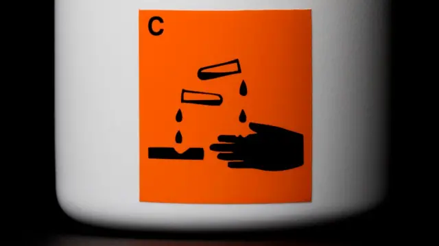 File image of a warning label on a bottle of corrosive liquid