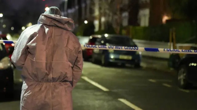 A forensic worker takes photographs of the scene