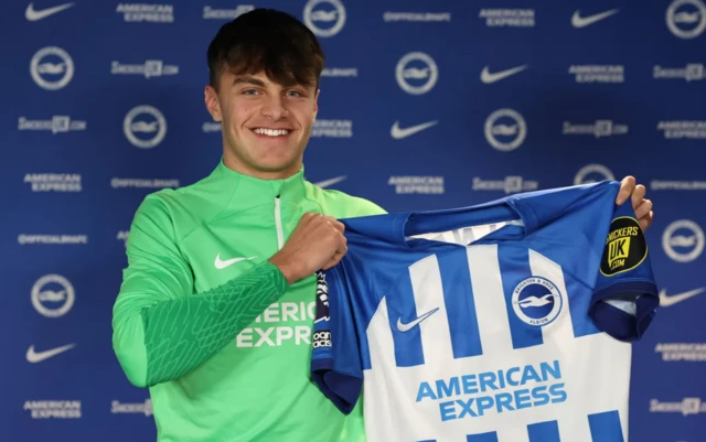 Josh Robertson poses with a Brighton shirt