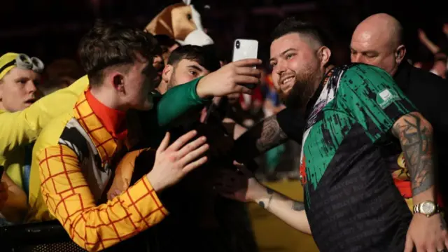 Michael Smith poses for a photo with fans in Cardiff