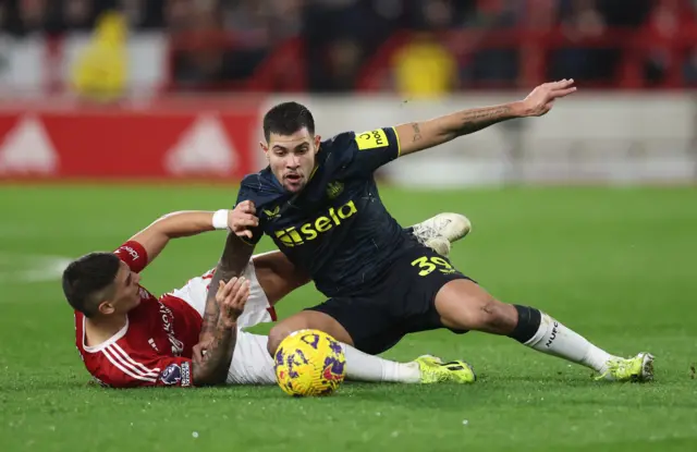 Guimaraes and Murillo battle for the ball in midfield.