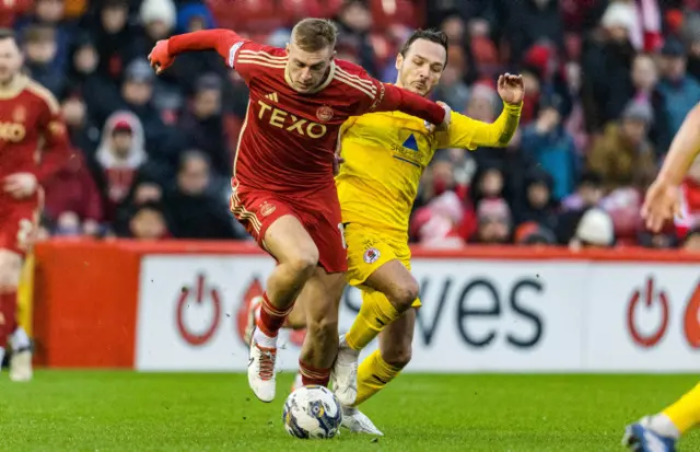 Aberdeen's Jack MacKenzie (L) and Bonnyrigg's Ross Gray in action during a Scottish Cup Fifth Round match between Aberdeen and Bonnyrigg Rose at Pittodrie Stadium, on February 10, 2024, in Aberdeen, Scotland.