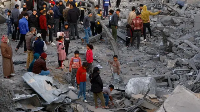 Palestinians gather at the site of an Israeli strike on a house in Rafah