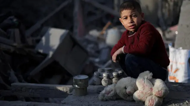 A Palestinian child looks on, at the site of an Israeli strike on a house