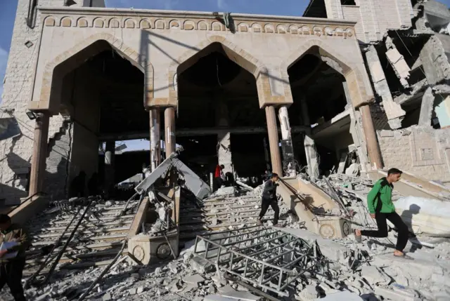 Palestinians inspect the site of an Israeli strike on the Al Huda mosque in Rafah, a city in Gaza