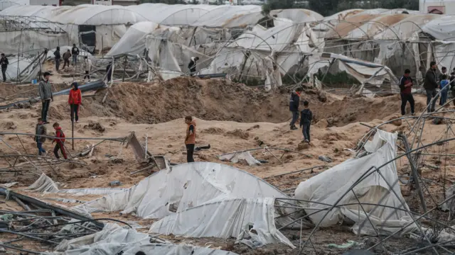 Palestinians inspect damage after an Israeli attack