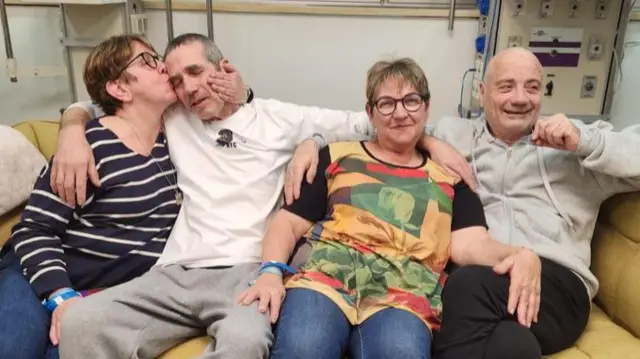 Louis Har and Fernando Simon Marman with their families after being released