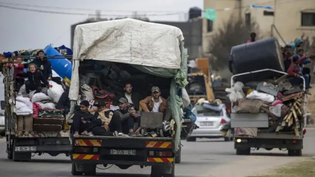 Dozens of people are crammed onto three lorries driving out of Rafah in south Gaza, alongside many personal belongings.