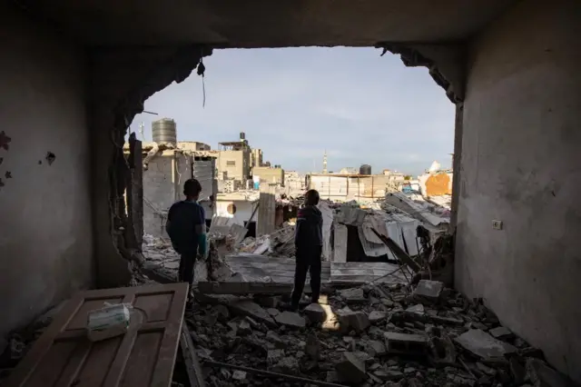 Palestinian children stand inside a destroyed apartment following an Israeli airstrike on the Rafah refugee camp in southern Gaza Strip