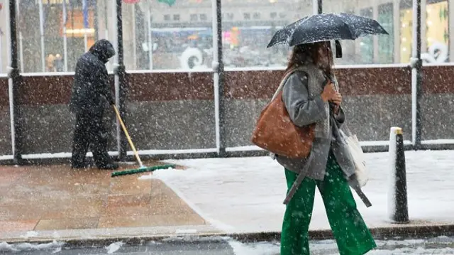 A woman walks in snow in New York on Tuesday morning