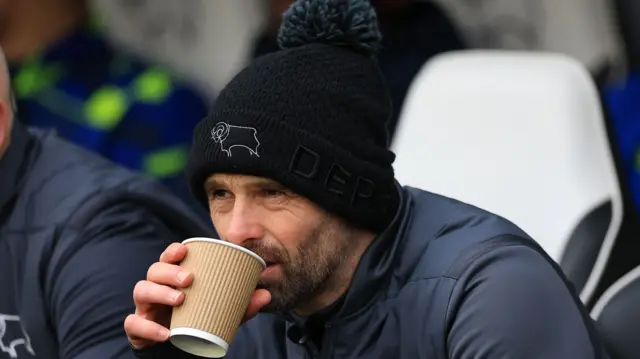 Derby manager Paul Warne sips a drink pensively