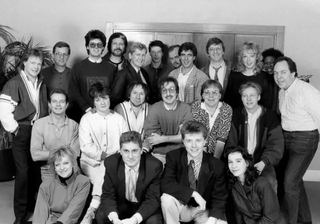 BBC Radio One DJs are pictured from 1987 Christmas week, including Steve Wright (centred in the middle row with his arms folded) and Nicky Campbell, his colleague, in the front row second from the right.