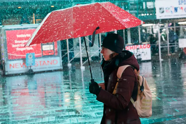 A woman walks through the snowfall in Times Square, NYC, on Tuesday morning