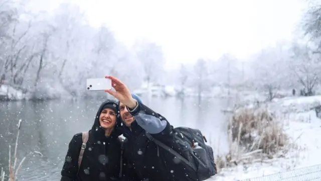 Couple snapping a picture in the snow