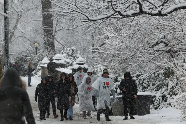 People walk in Central Park in the snow