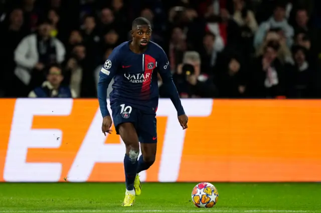 Ousmane Dembele runs with the ball in midfield.