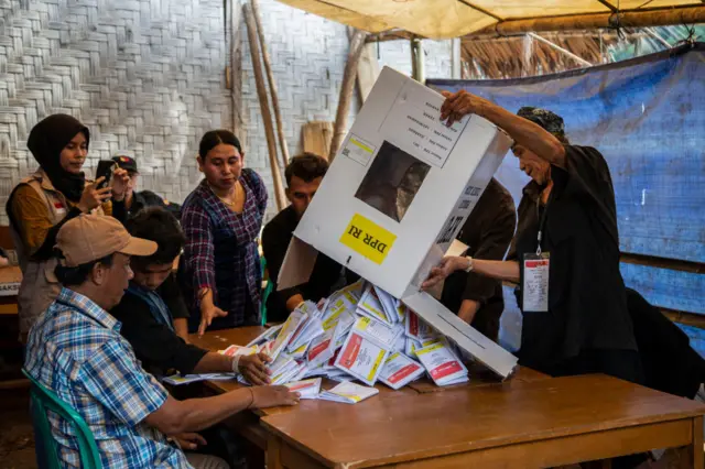 An election official empties a ballot box in Kenekes village in the Banten province