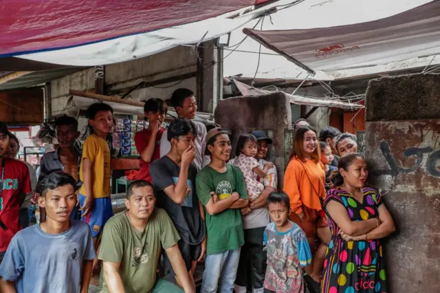 People watch as votes are being counted at a polling booth in Jakarta