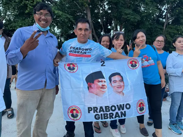 Crowds of Prabowo supporters, mostly in blue, are filing into the stadium with smiles on their faces