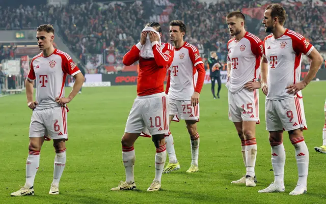 Bayern players stand in front of the away fans after their defeat at Leverkusen.