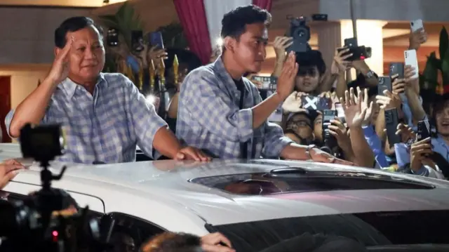 Indonesia's Defence Minister and presidential candidate Prabowo Subianto accompanied by Indonesia's vice president candidate Gibran Rakabuming Raka, who is the eldest son of Indonesian President Joko Widodo and current Mayor of Surakarta, greet supporters from a car in Jakarta, Indonesia February 14, 2024.