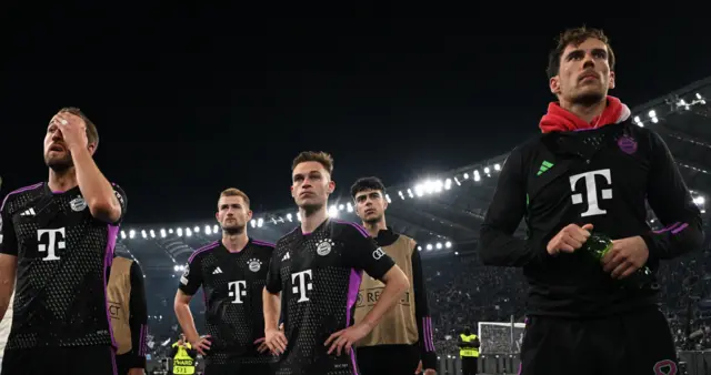 Bayern players stand in front of the away fans after their loss.