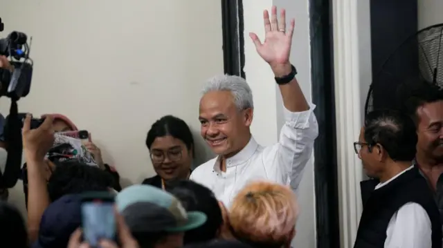 Ganjar Pranowo waving to journalist earlier. His running mate, Mahfud MD, is on the right in the black vest.