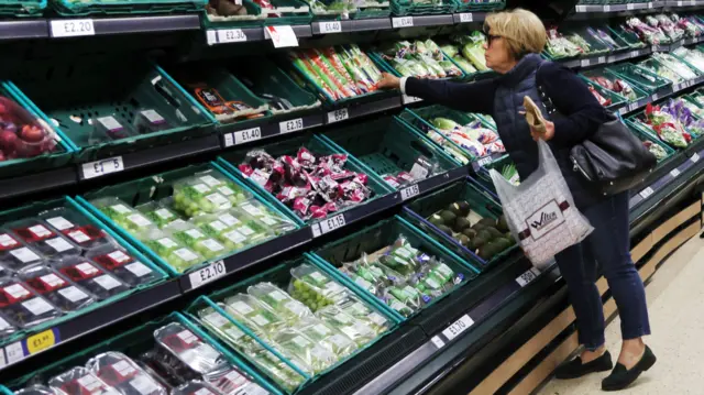 A woman picks groceries at a supermarket